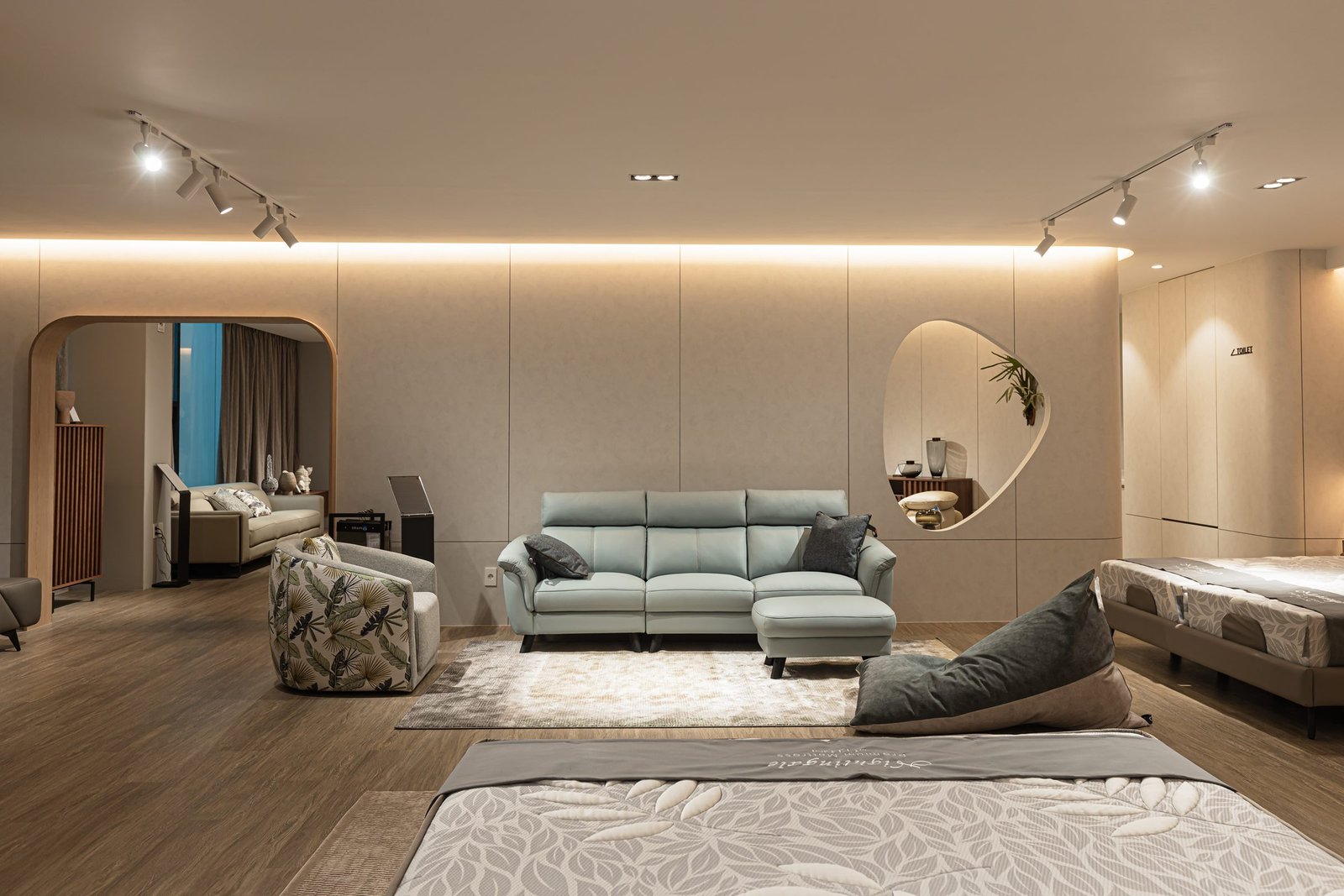Open showroom floor with sofas, beds and arched timber portal