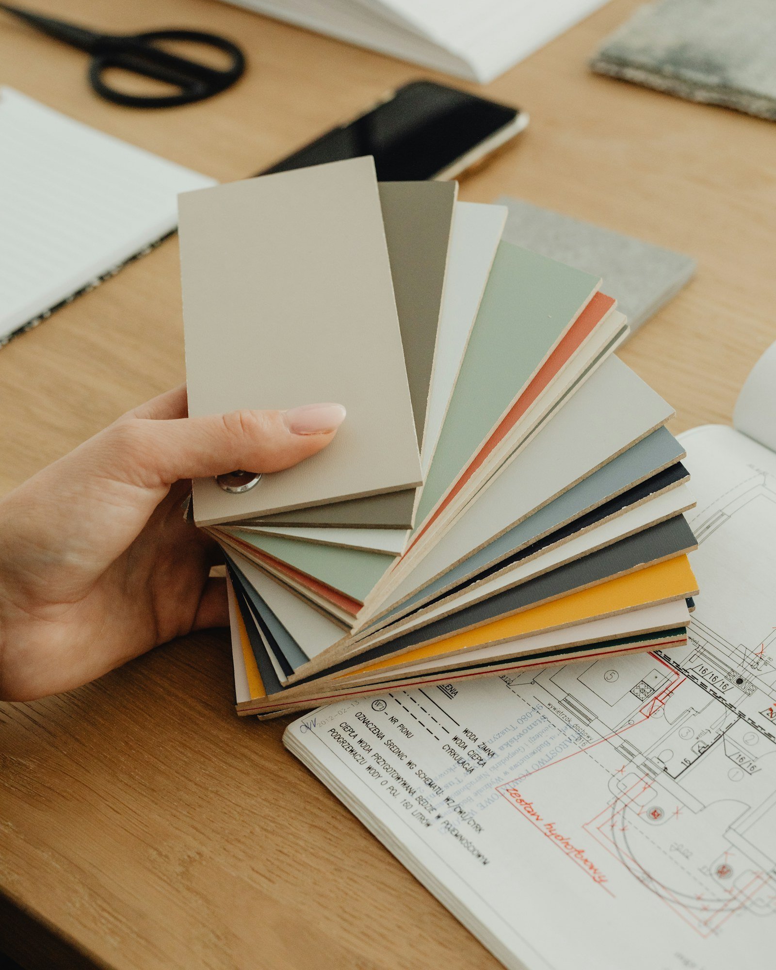 Colour swatches held over architectural drawings